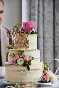 Zweistöckige Hochzeitstorte mit Blumen und einem "Mr & Mrs"-Topper.