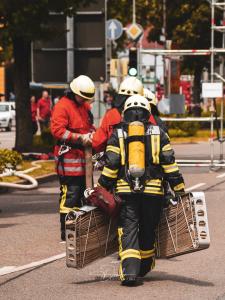 Feuerwehrleute in Einsatzkleidung bei einer Rettungsaktion auf der Straße.