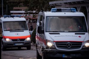 Zwei Einsatzfahrzeuge des Deutschen Roten Kreuzes fahren auf einer Straße.