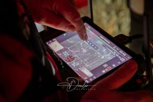Nahaufnahme eines Tablets, das zur Steuerung einer Drohne verwendet wird. Ein Finger tippt auf den Bildschirm.