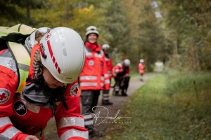 Rettungskräfte des Deutschen Roten Kreuzes in Schutzkleidung bei einer Übung im Wald.